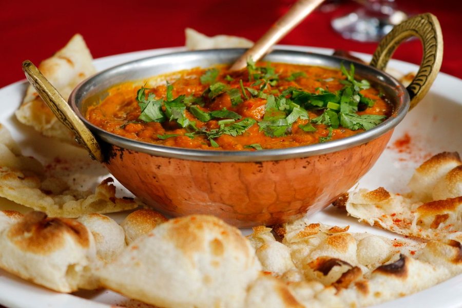 Curry in a copper dish served with naan (illustrative stock photo)